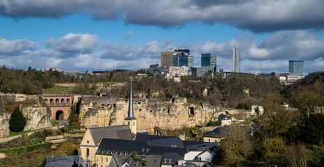 Obraz premium wide horizontal panorama view of Luxembourg City with medieval houses, the fortress wall, and the Kirchberg skyline in the background
