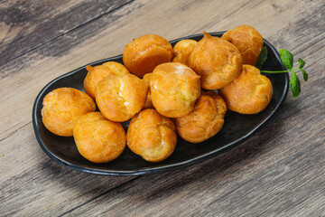 Sweet tasty profiteroles heap in the bowl