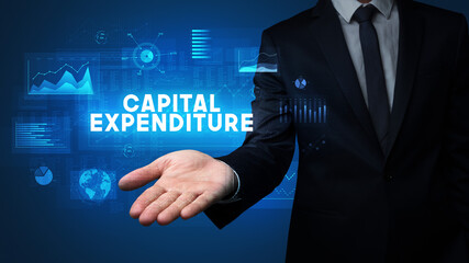 Hand of Businessman holding CAPITAL EXPENDITURE inscription, business success concept