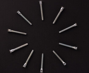 self-tapping screws for furniture assembly, clamping screw, furniture screw on a black background. Background with place for text