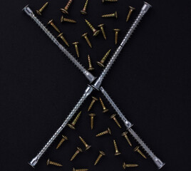 The abstract form and background for the text is made of self-tapping screws and furniture screws on a black background (top view).