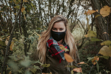 Woman with black mask in autumn Athomsphere protected from coronavirus