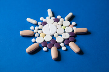 Covid-19 corona virus cure. Colorful medical pills on blue background for ncov-19 diseases...