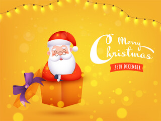 Merry Christmas Celebration Concept with Cute Santa Claus Inside a Gift Box and Illuminated Lighting Garland on Yellow Bokeh Background.
