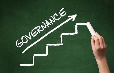 Hand drawing GOVERNANCE inscription with white chalk on blackboard, business concept