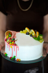 The holiday cake is decorated with fruit and colorful dragees