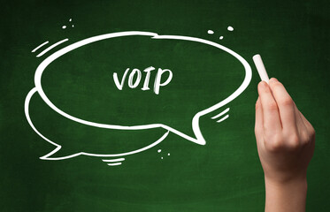 Hand drawing VOIP abbreviation with white chalk on blackboard