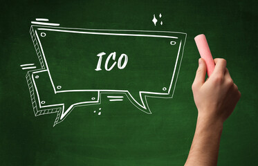 Hand drawing ICO abbreviation with white chalk on blackboard