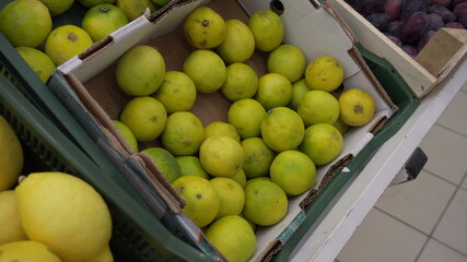 Green limes on the market in a basket.