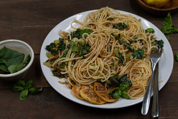 Vegan lemon and basil infused spaghetti dish on wooden table