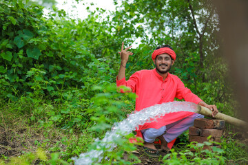 indian farmer with water flow from pipe at field