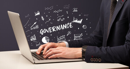 Businessman working on laptop with GOVERNANCE inscription, modern business concept