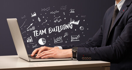 Businessman working on laptop with TEAM BUILDING inscription, modern business concept