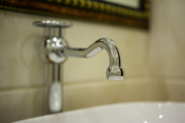 Water tap on a light tile background.