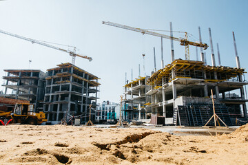 two construction crane on the background of construction site and blue sky