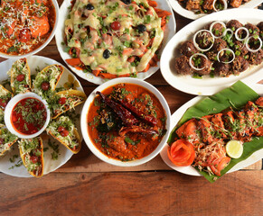 Assorted indian foods chicken masala,paneer tikka,mutton kola and washington pasta on wooden background. Dishes and appetizers of indian cuisine