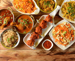Assorted indian foods sabudana kichidi,chicken lollipop,chicken masala and schezwan fried rice on wooden background. Dishes and appetizers of indian cuisine