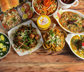 Assorted indian foods pav bhaji,veg ball manchurian,mutter paneer, malai kofta and palak paneer on wooden background. Dishes and appetizers of indian cuisine