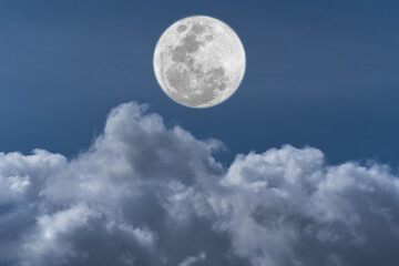 Obraz na płótnie Canvas Full moon over clouds on the sky.
