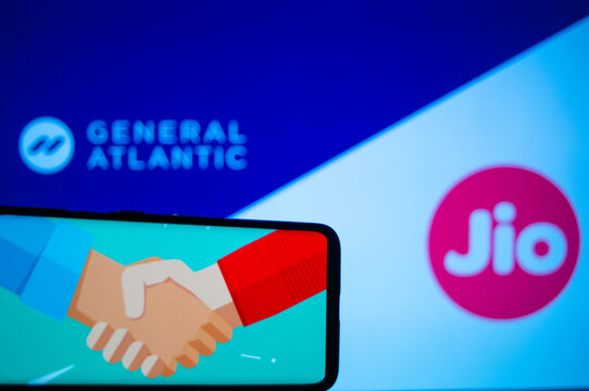 Mobile phone with a handshake screen and general atlantic and jio in the background