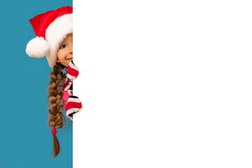 A child looks out from behind a white background on Christmas day.