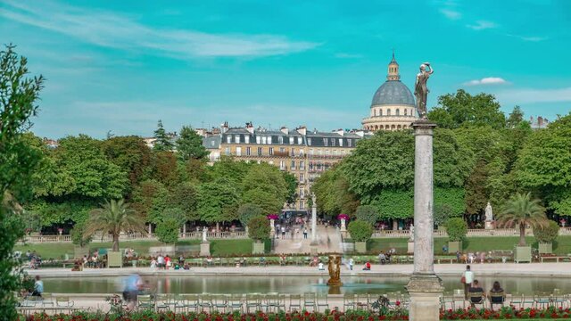 The beautiful view of the Luxembourg Gardens timelapse with fountain in Paris, France. Blue cloudy sky at summer day.