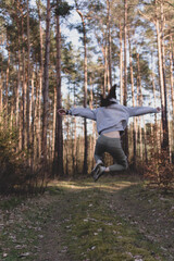 Młoda dziewczyna  skacze w lesie