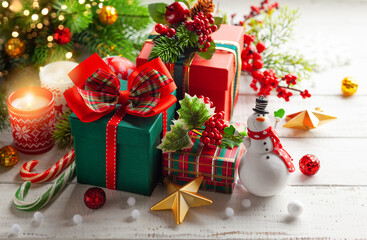 Winter composition with Christmas gift boxes, holiday sweets and Christmas decorations on wooden table.