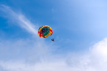 Fototapeta na wymiar Parasailing in blue sky. Sports, active leisure, travel, vacation concept