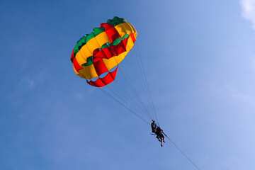 Parasailing in blue sky. Sports, active leisure, travel, vacation concept