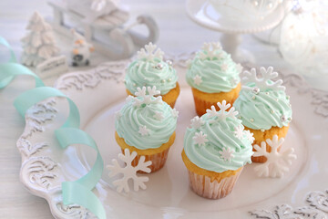 Christmas cupcakes with mint blue cream and white snowflakes on Christmas decoration table background. クリスマススノーフレークカップケーキ