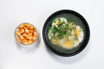 Broth with croutons top view on a light background