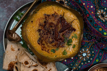 Indian dal. Traditional Indian tempered lentils. Indian Dhal spicy curry in bowl, spices, herbs, rustic gray metal background. Authentic Indian dish.