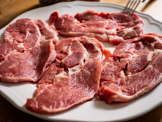 Raw pork chops on plate