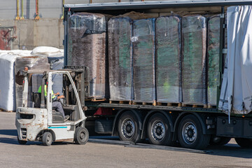 Wheelbarrow loading a peat pallet onto a truck.