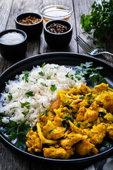 Chicken meat with rice and vegetables on wooden table
