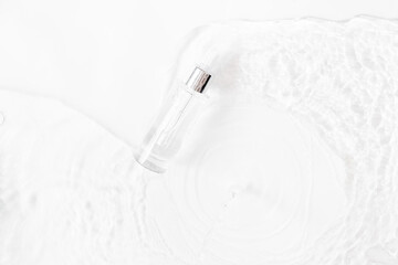Glass Bottle with fluid collagen and hyaluronic acid, hydration skin. Top flatlay view copyspace. Abstract water background.