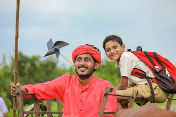 Naklejka premium Indian farmer and his child on bullock cart