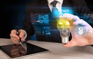 Businessman holding lightbulb with PRIVACY POLICY inscription, online security idea concept