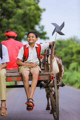 Cute indian child going to school on bullock cart