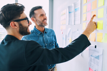 Two smiling businessmen planning business strategy at office