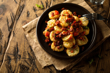 Homemade gnocchi with fried sausage and tomato