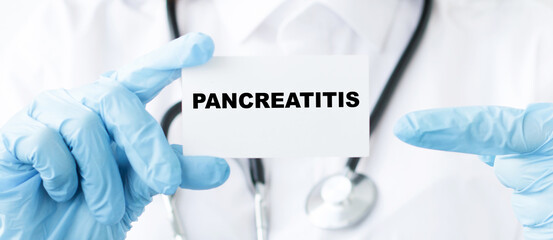 Doctor holds a card with the name of the diagnosis - pancreatitis. Close-up of hands in gloves holding a card. Medical concept.