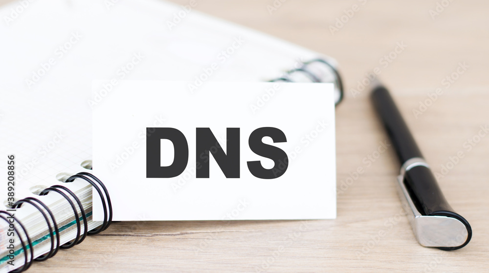 Poster dns, domain name system, text on white card next to notepad and pen on table