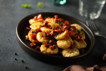Homemade gnocchi with fried sausage and tomato