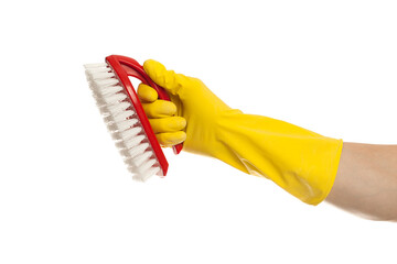 Hand in yellow glove with a red cleaning brush on a white background. Home cleaning concept