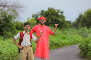 indian farmer with his child on road side and asking lift for going to home