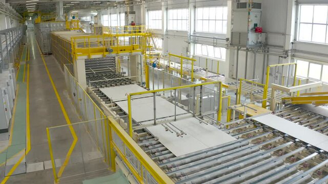Manufacturing drywall or gypsum board by conveyor on factory. Production of building materials or plasterboard sheet