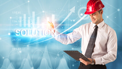 Young businessman with helmet drawing SOLUTION inscription, modern business technology concept