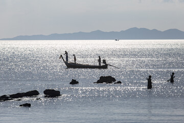 Krabi Thailand 12.16.2015 looking out to sea with fishermen silhouetted silver